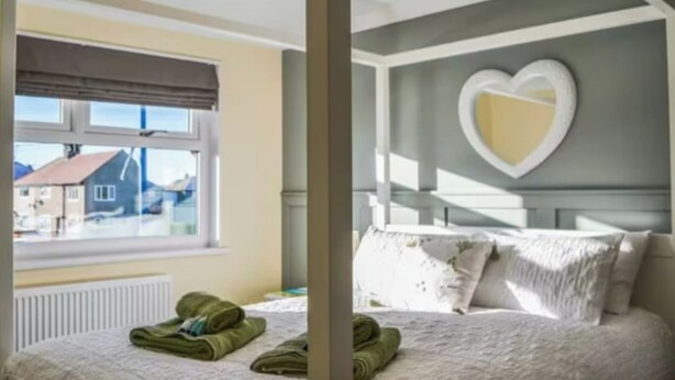 Une chambre à coucher avec un lit, une fenêtre et une vue sur les maisons à l’extérieur.