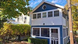 A two-story house with a blue and white exterior, a visible front door, and a small porch area.