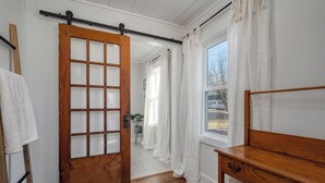 Une pièce avec une porte en bois, un banc et une vue par la fenêtre.