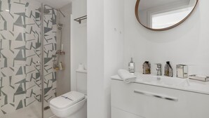 A modern bathroom with a glass shower enclosure, a toilet, and a vanity with a mirror. - Colorful Flat in Riviera del Sol Ref 27 (Mijas)