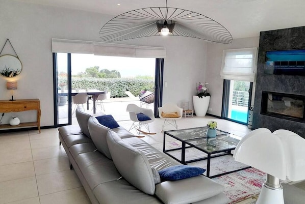 Relax in this stylish living room with a comfortable sofa, glass coffee table, and a fireplace.