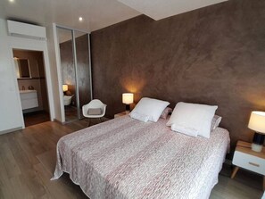 Relax in a serene space with a large bed, two bedside tables, and a large mirror.