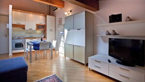 A modern kitchen with a dining area, a flat-screen TV, and a fireplace. - La Colombina (Verona)