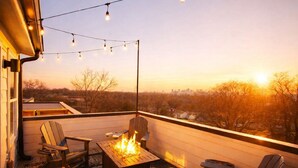 A rooftop deck with a fire pit, chairs, and string lights. - 🌇 Nashville Rooftop Retreat - Fire Pit, Skyline Views, Sleeps 12! 🎶 (Nashville)