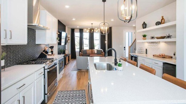 A modern kitchen with a large island, white cabinetry, and pendant lighting. - 🌇 Nashville Rooftop Retreat - Fire Pit, Skyline Views, Sleeps 12! 🎶 (Nashville)