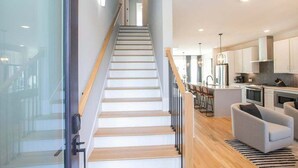 A modern kitchen with white cabinets, a central island, and stainless steel appliances. - 🌇 Nashville Rooftop Retreat - Fire Pit, Skyline Views, Sleeps 12! 🎶 (Nashville)