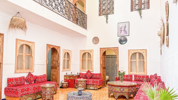 Un interior espacioso con sofás ornamentados, un techo alto y una decoración tradicional.