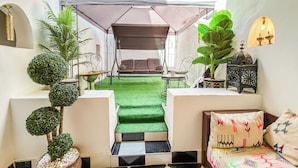 Un espacio interior acogedor con una zona amueblada con toldo, un sofá y una mesa de comedor.
