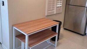 Eine Küche mit einem Holztisch, einem weißen Schrank und einem Edelstahl-Kühlschrank.