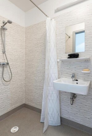 Een douche, handdoeken, zeep, toiletpapier