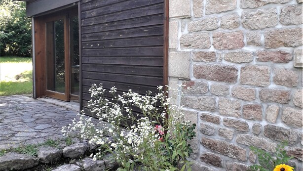 Un edificio con muro de piedra y revestimiento de madera.