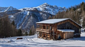 A wooden cabin with a snow-covered roof, situated in a snowy mountainous area. - 100% RENOVATED FAMILY CHALET with view! (Arvieux)