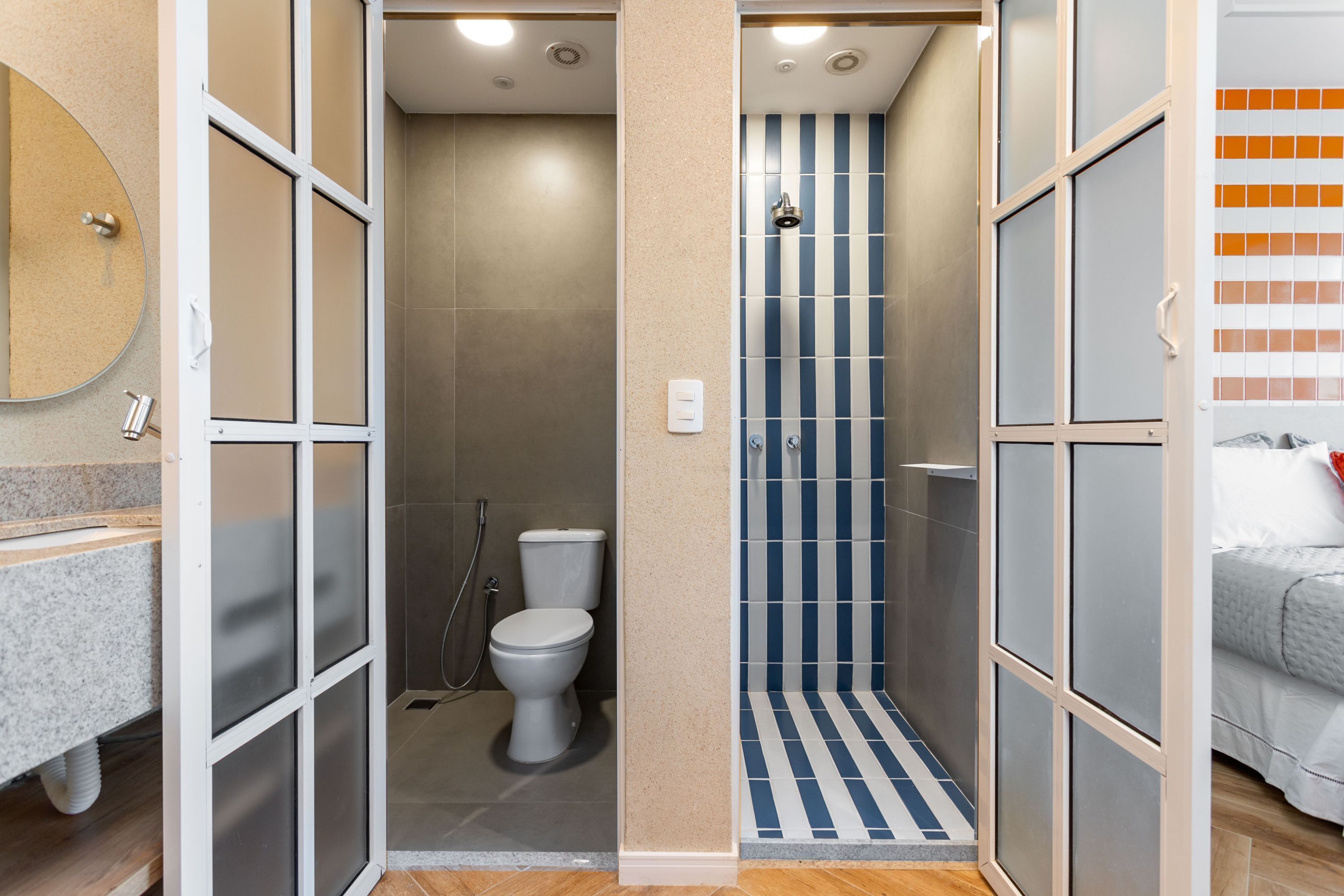 A bathroom with a shower, toilet, and a mirror.