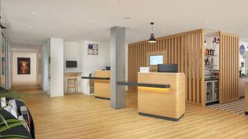 A modern reception area with wooden reception desks, a flat-screen TV, and a coffee bar with a refrigerator.