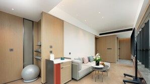 Una habitación de hotel moderna con sofá, una mesita, una esfera decorativa y un armario.