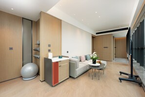 Een moderne hotelkamer met een bank, een klein tafeltje, een decoratieve bal en een kast.