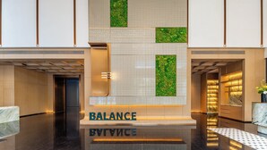 Un vestíbulo moderno con un mostrador de recepción que dice "BALANCE" y una pared espejada.