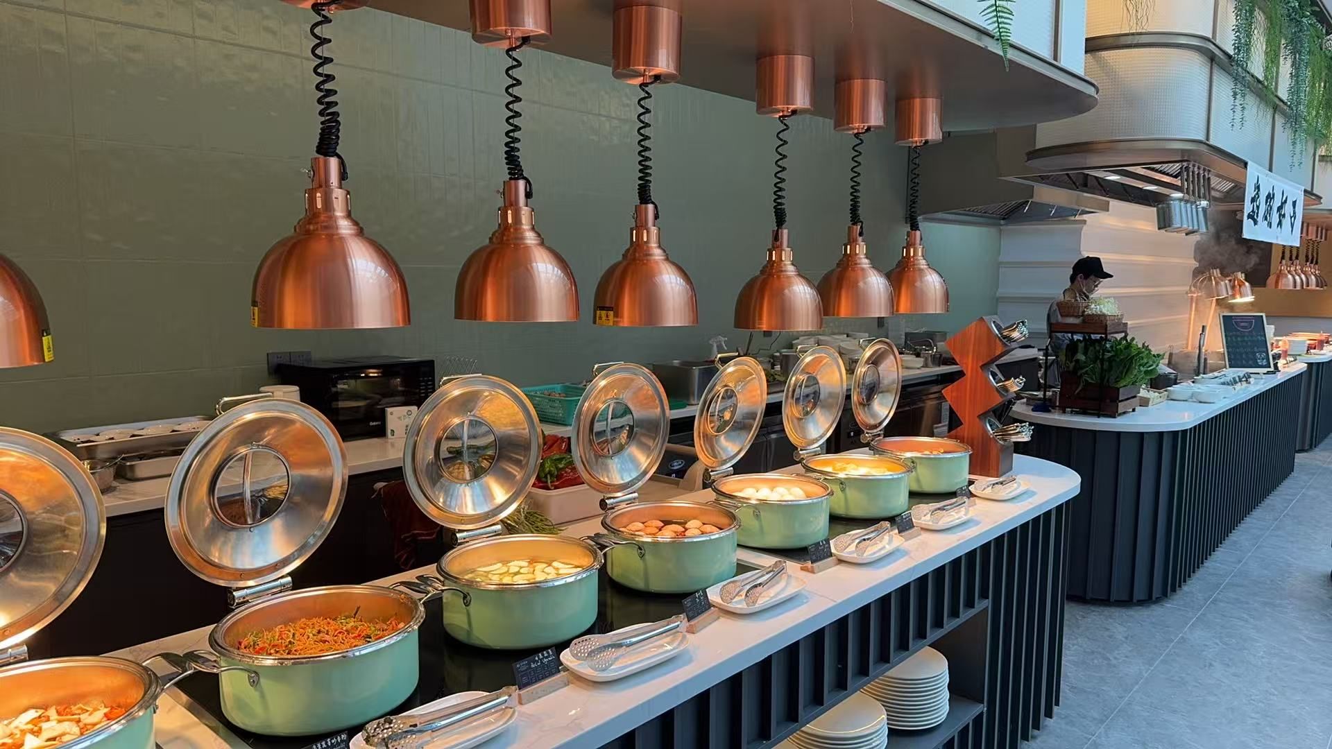 A buffet setup with various food containers and utensils.
