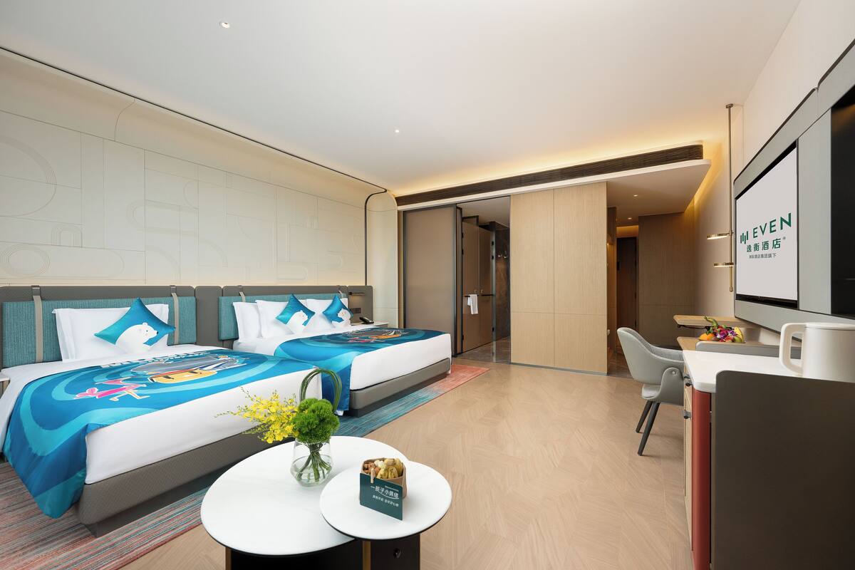 Una habitación de hotel moderna con una cama grande, un escritorio y un televisor.