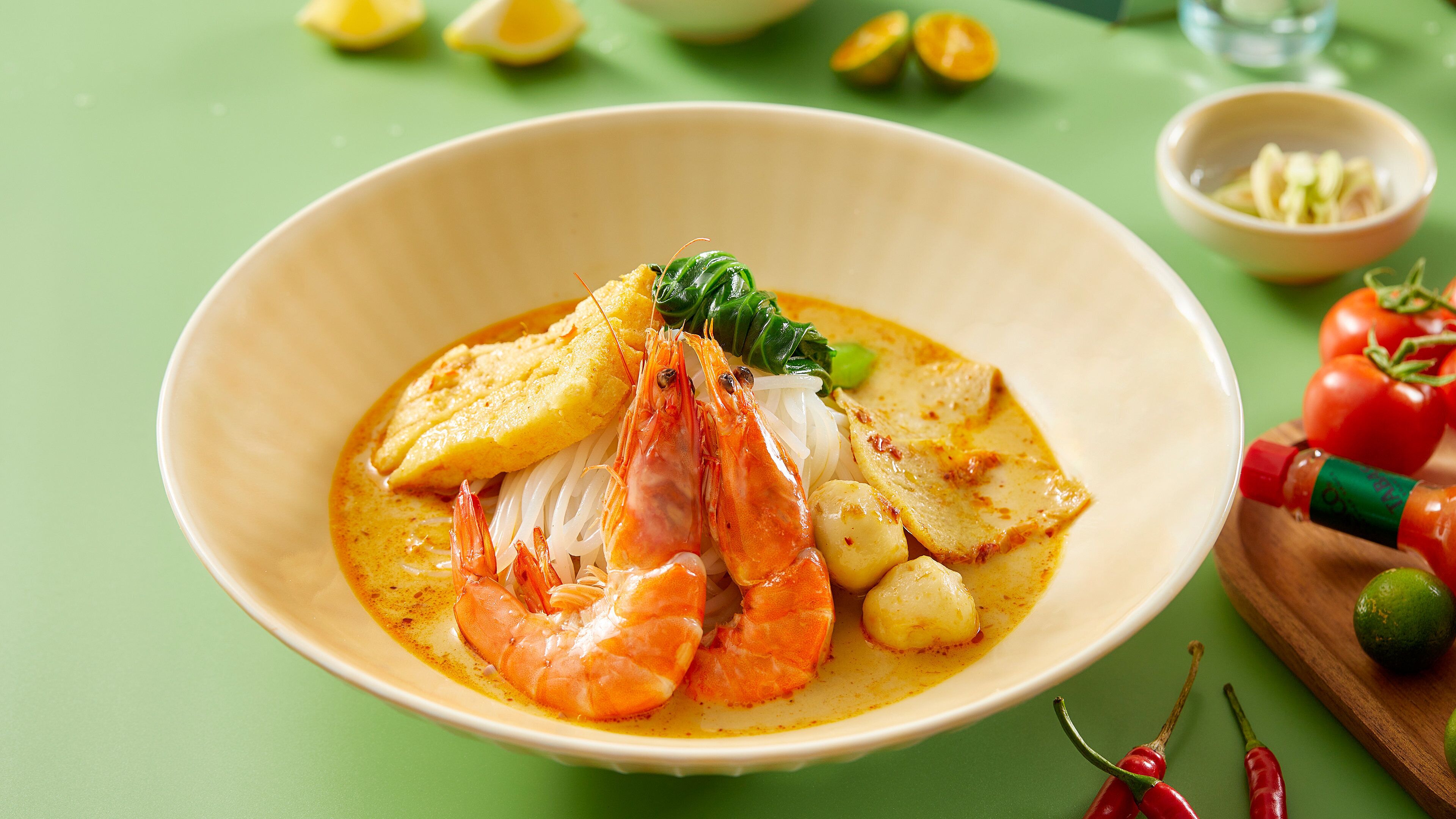A bowl of seafood soup with shrimp, fish, and vegetables.