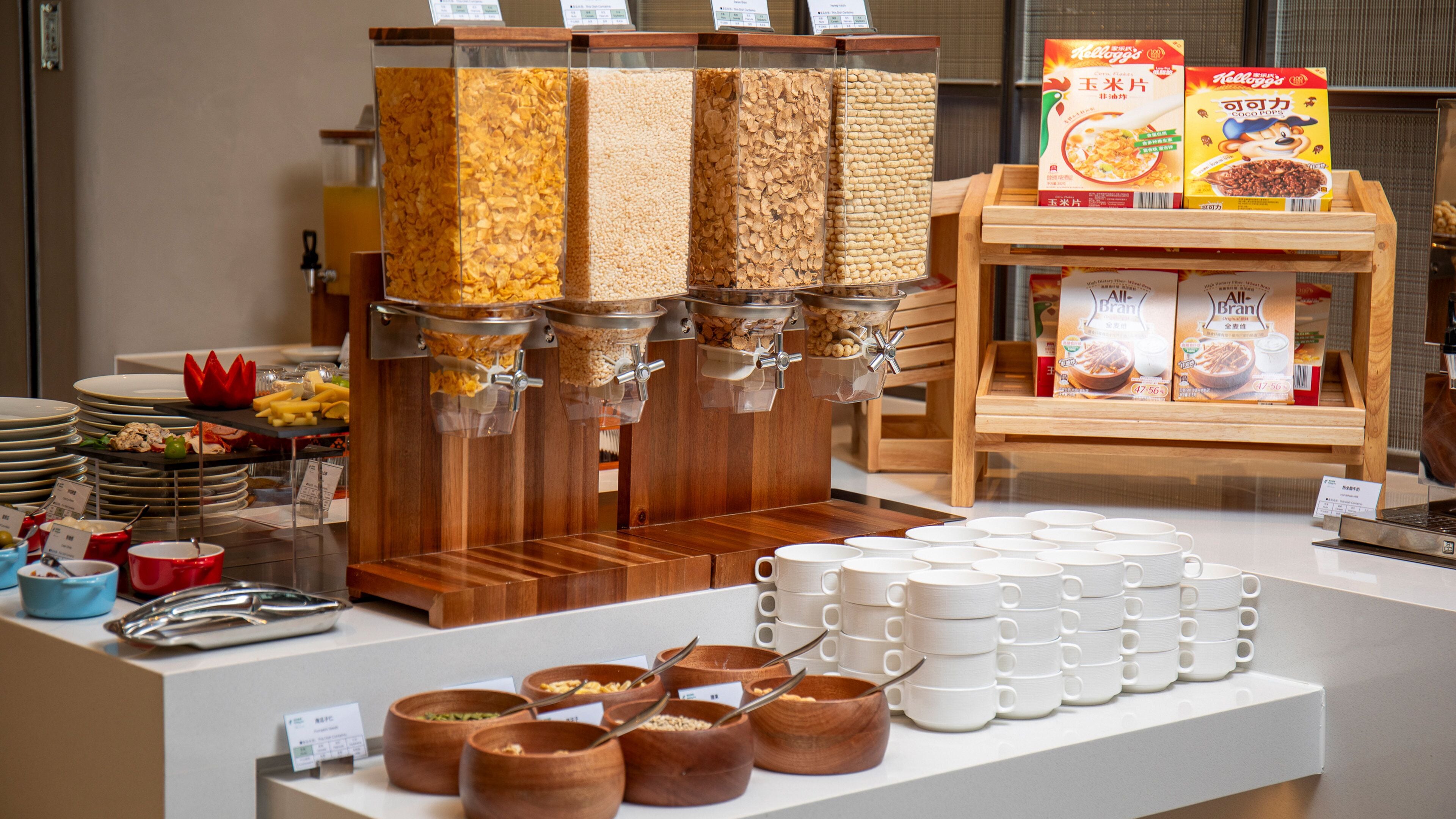 A breakfast buffet with various food options and serving utensils.