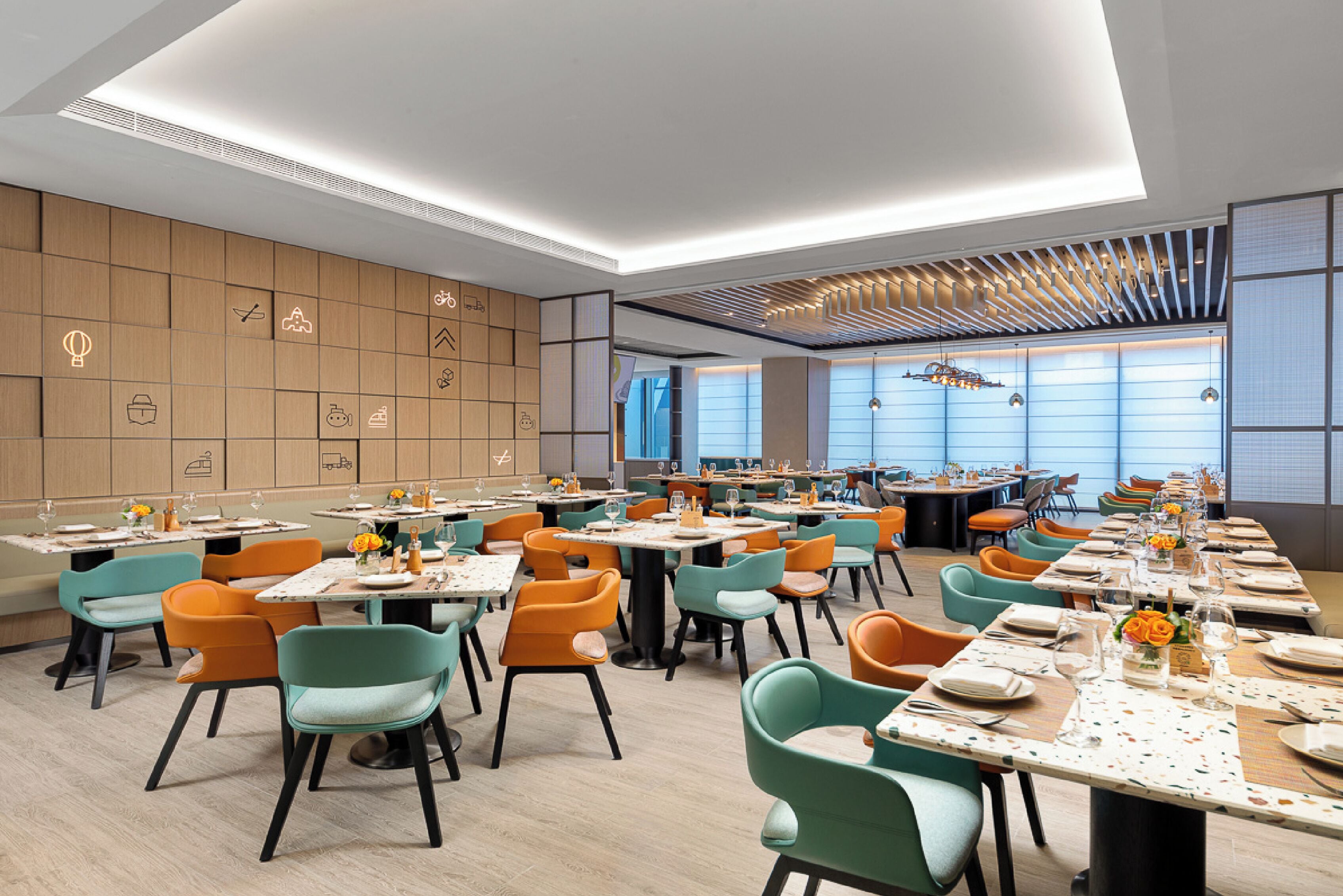 A modern dining area with multiple tables and chairs, featuring a variety of seating options and a clean, contemporary design.