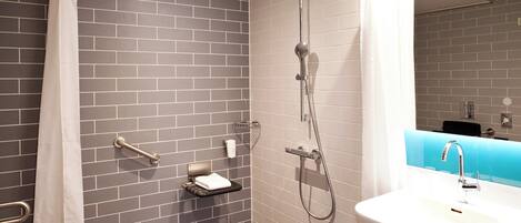 A modern bathroom with a shower, a sink, and a towel rack.