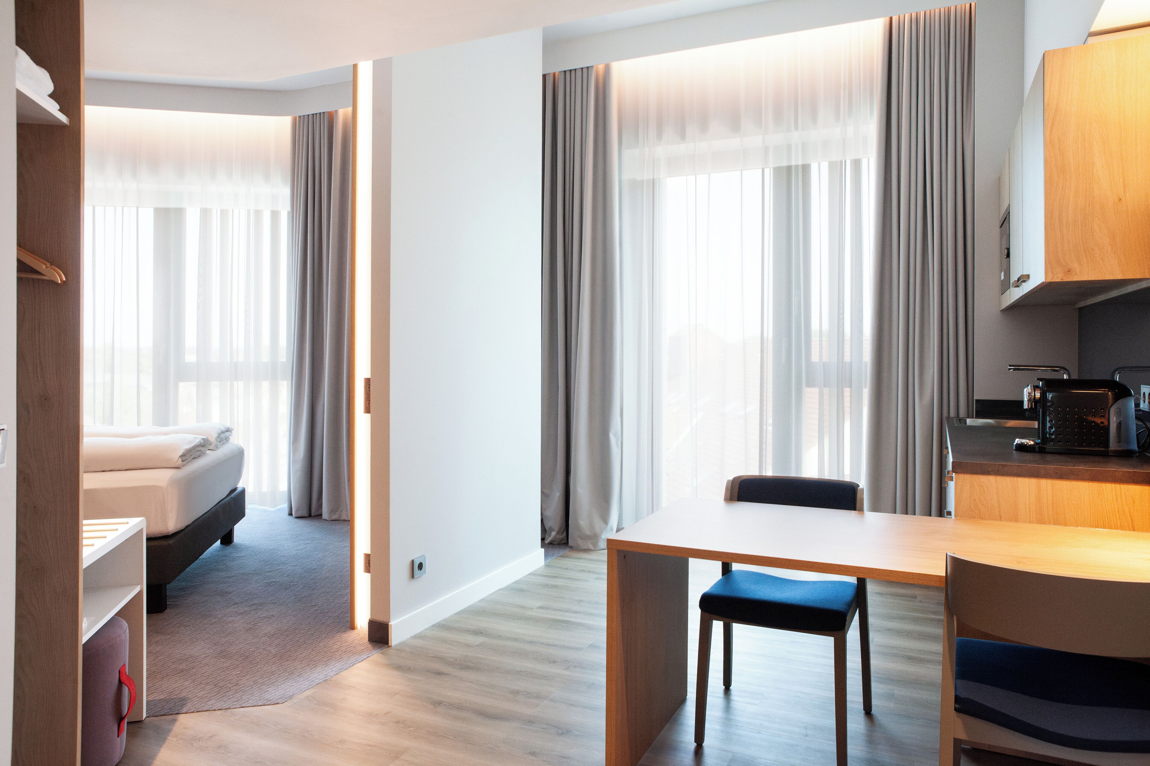 Et moderne hotelværelse med seng, spisebord og tekøkken.