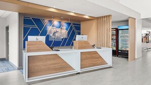Un comptoir d’accueil au design moderne, avec une palette de couleurs bleu et blanc et un élément décoratif en bois.