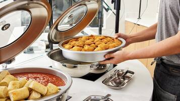 Una mesa de buffet con diversos alimentos y utensilios.