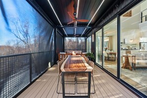 Enjoy meals al fresco in this enclosed outdoor space with a dining table and comfortable seating.