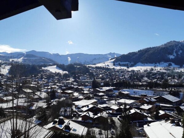 A snowy village with houses and mountains in the background.