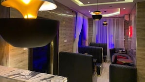A modern interior with a dining area, seating, and a ceiling with recessed lighting. - Hiltons Bellaire (Abuja)