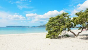 Ein Strand mit weißem Sand und blauem Himmel.