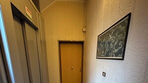 A narrow hallway with a tiled floor, a wooden door at the end, and a framed picture on the wall. - SINGLE APARTMENT 700 METERS FROM THE CENTER OF MILAN (Milano)