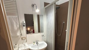 A bathroom with a sink, mirror, towel rack, and shower. - SINGLE APARTMENT 700 METERS FROM THE CENTER OF MILAN (Milano)