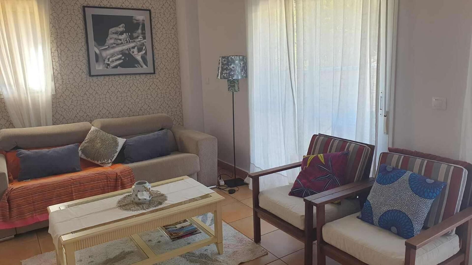 Un salón con sofá, sillón y mesa de centro.