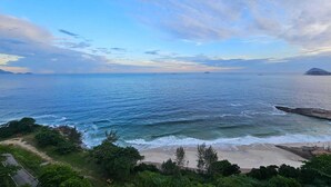 A coastal view with a sandy beach, rocky outcrops, and dense greenery. - Charming apartment with sea view in Copacabana (Ipanema Rio de Janeiro)