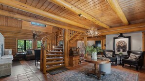 A wooden interior with a spiral staircase, a fireplace, and a bear painting. - Snowberry Inn: Large Kitchen & Gathering Room 9BR 11BA Ensuite bath in all rooms (Eden)