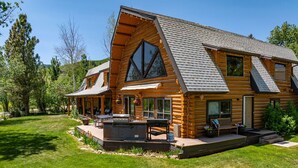 A log cabin with a large deck, outdoor seating, and a covered patio area. - Snowberry Inn: Large Kitchen & Gathering Room 9BR 11BA Ensuite bath in all rooms (Eden)