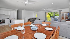 A modern kitchen with white cabinets and a dining area with a wooden table set for four.