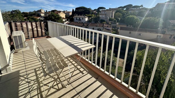 A balcony with a view of a residential area, a white railing, and a sunshade. - APARTMENT FOR 4 PEOPLE IN A RESIDENCE WITH POOL NEAR THE SEA  AND TOWN CENTER (STE MAXIME)