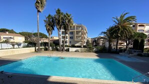 A rectangular swimming pool with clear blue water, surrounded by a pebble deck. - APARTMENT FOR 4 PEOPLE IN A RESIDENCE WITH POOL NEAR THE SEA  AND TOWN CENTER (STE MAXIME)