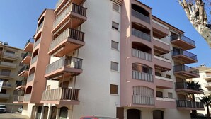 A multi-story residential building with balconies, a car parked in front, and a tree to the right. - APARTMENT FOR 4 PEOPLE IN A RESIDENCE WITH POOL NEAR THE SEA  AND TOWN CENTER (STE MAXIME)