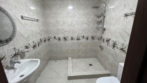 Une salle de bain avec un lavabo, des toilettes et une douche.