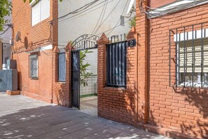 A brick building with a gated entrance, numbered 2, and a satellite dish on the roof.