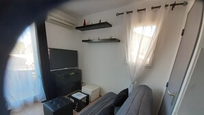 A living room with a sofa, a TV, a coffee table, and a small white table. - Under the Alpilles sun  (Mouriès)