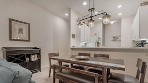 A dining area with a wooden table, benches, and a chandelier. - COMFORTABLE APARTMENT - A REAL VACATION SPOT. HAS EVERYTHING YOU NEED-POOLS-LAKE (Davenport)