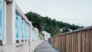 Une promenade en bois mène à un bâtiment dont les fenêtres sont encadrées de bleu.