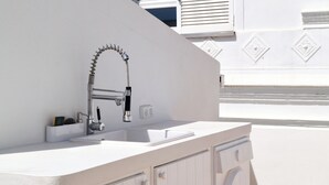 A modern kitchen with a white countertop, stainless steel faucet, and built-in cabinets. - Casa Pasha - Olhão, Algarve (Olhão)